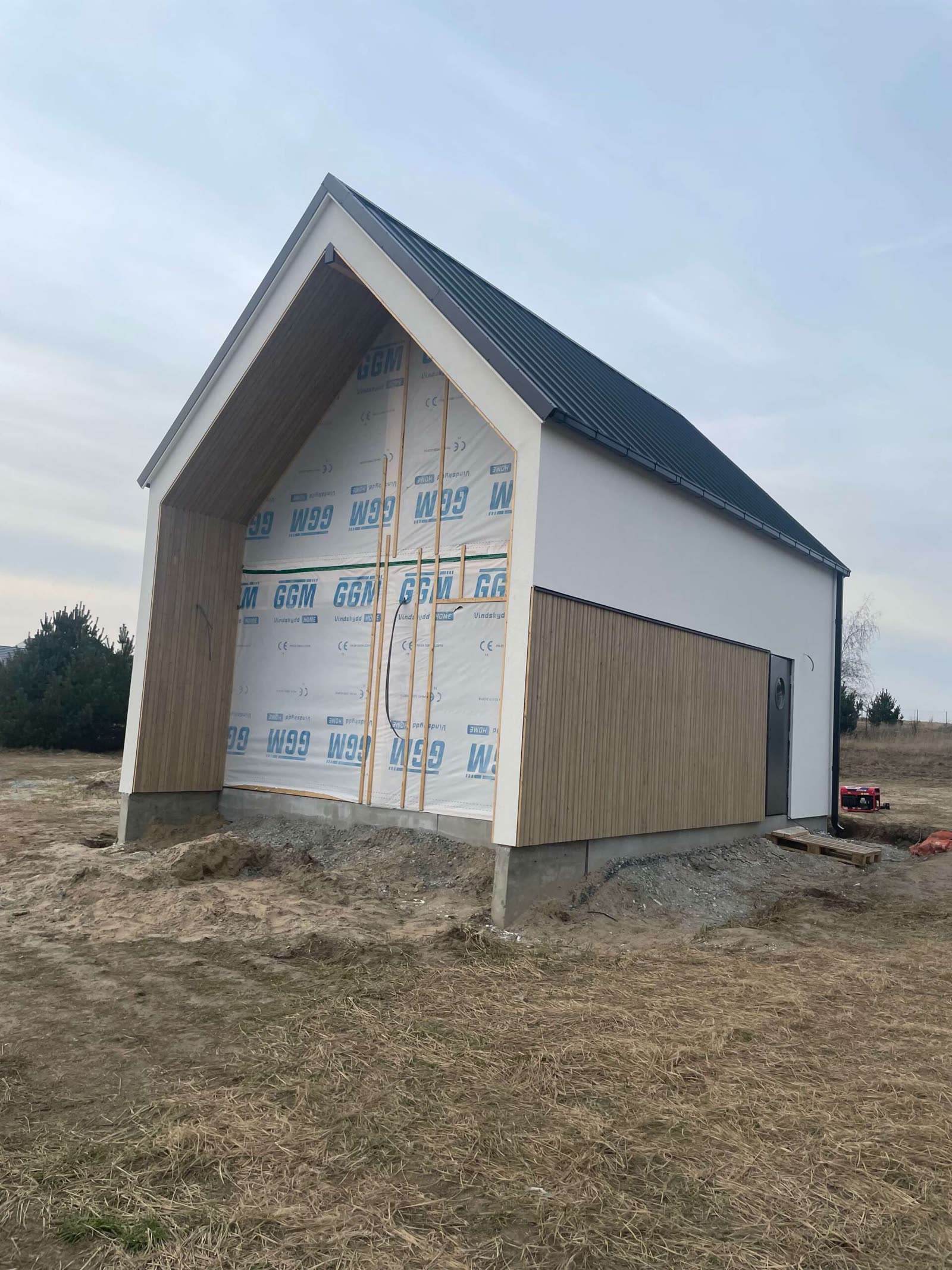 Budowa — ściana szczytowa z membraną izolacyjną i drewnianą okładziną